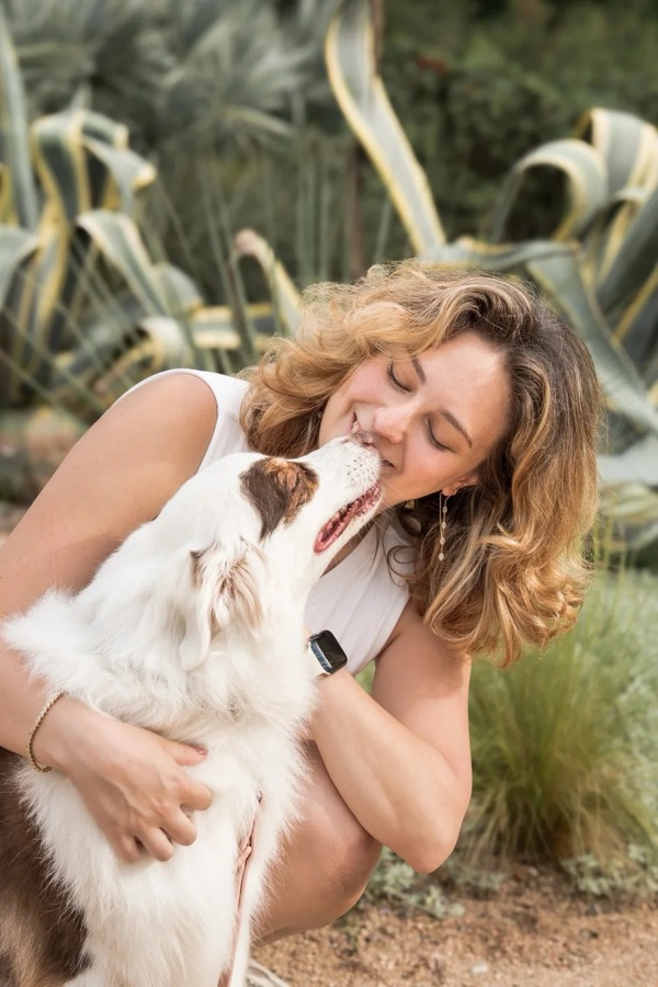Alex smiling with an Australian shepherd in her arms